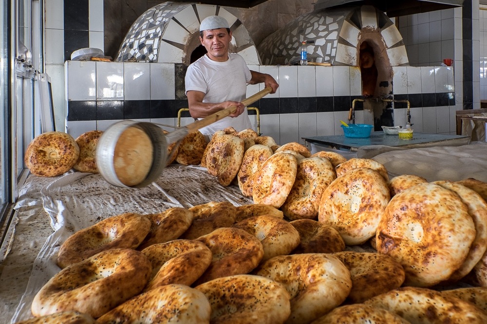 Maestro panettiere nonvoy mentre sforna il pane caldo dal tandir